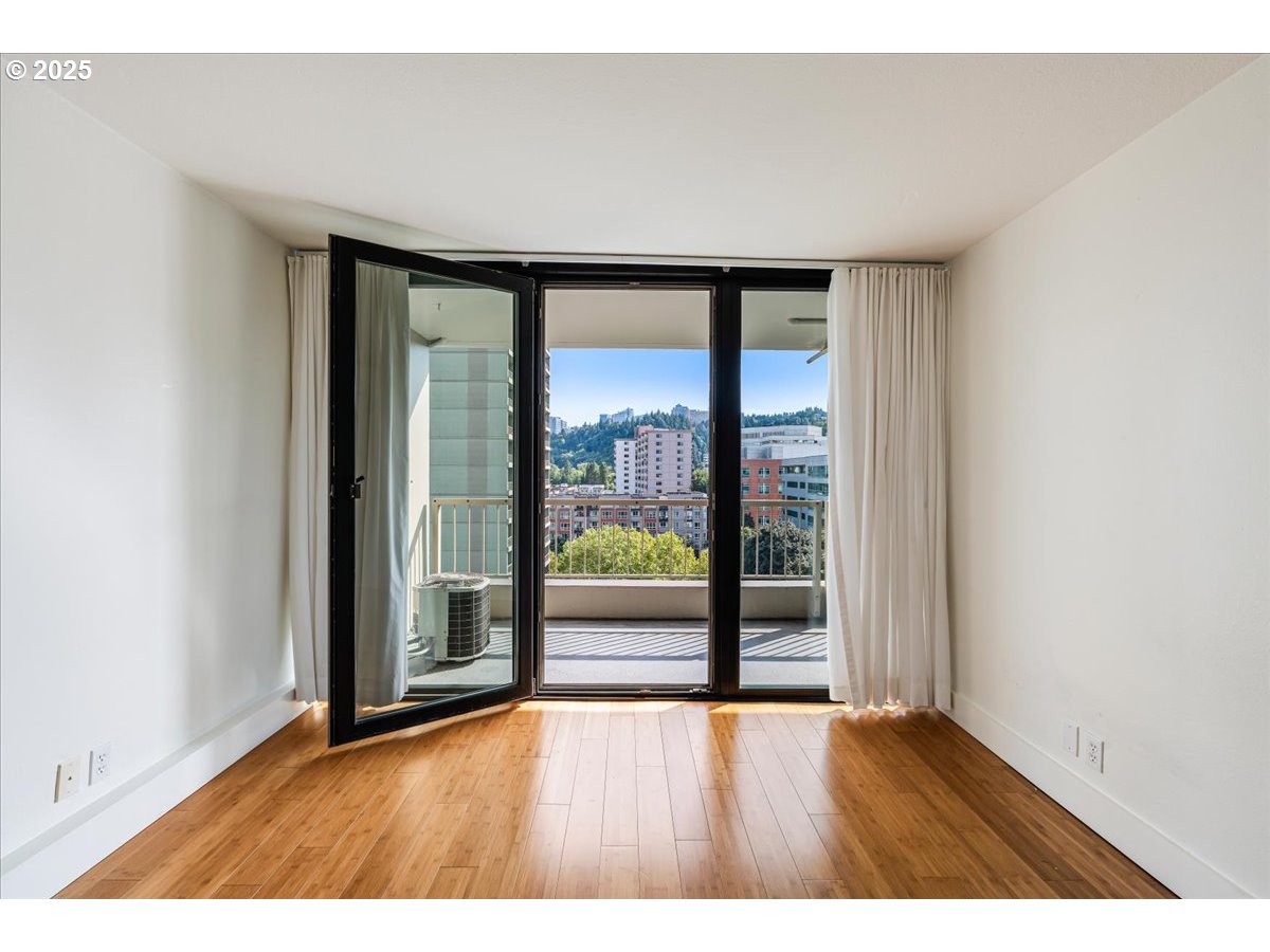 255 Southwest Harrison Street, Unit 11A Portland, OR 97201 - Photo 5 of 32 an empty room with wooden floor and windows