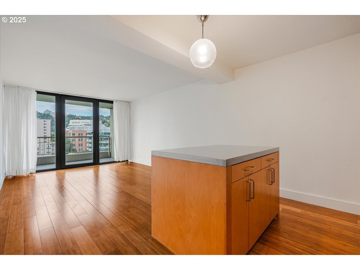 255 Southwest Harrison Street, Unit 11A Portland, OR 97201 - Photo 9 of 32 a view of an empty room with wooden floor and a window
