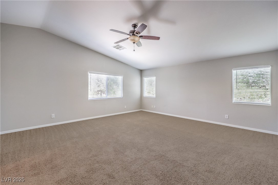 585 Foster Springs Road Las Vegas, NV 89148 - Photo 20 of 39 Unfurnished room with lofted ceiling, a ceiling fan, plenty of natural light, and carpet floors