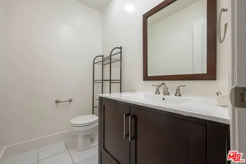 a bathroom with a granite countertop toilet sink mirror and