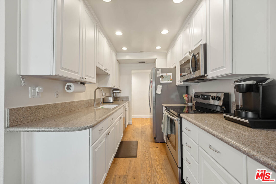 1515 South Beverly Drive, Unit 201 Los Angeles, CA 90035 - Photo 9 of 22 a kitchen with stainless steel appliances granite countertop a sink stove and refrigerator