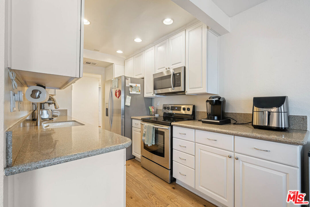 1515 South Beverly Drive, Unit 201 Los Angeles, CA 90035 - Photo 10 of 22 a kitchen with kitchen island a counter top space appliances and cabinets