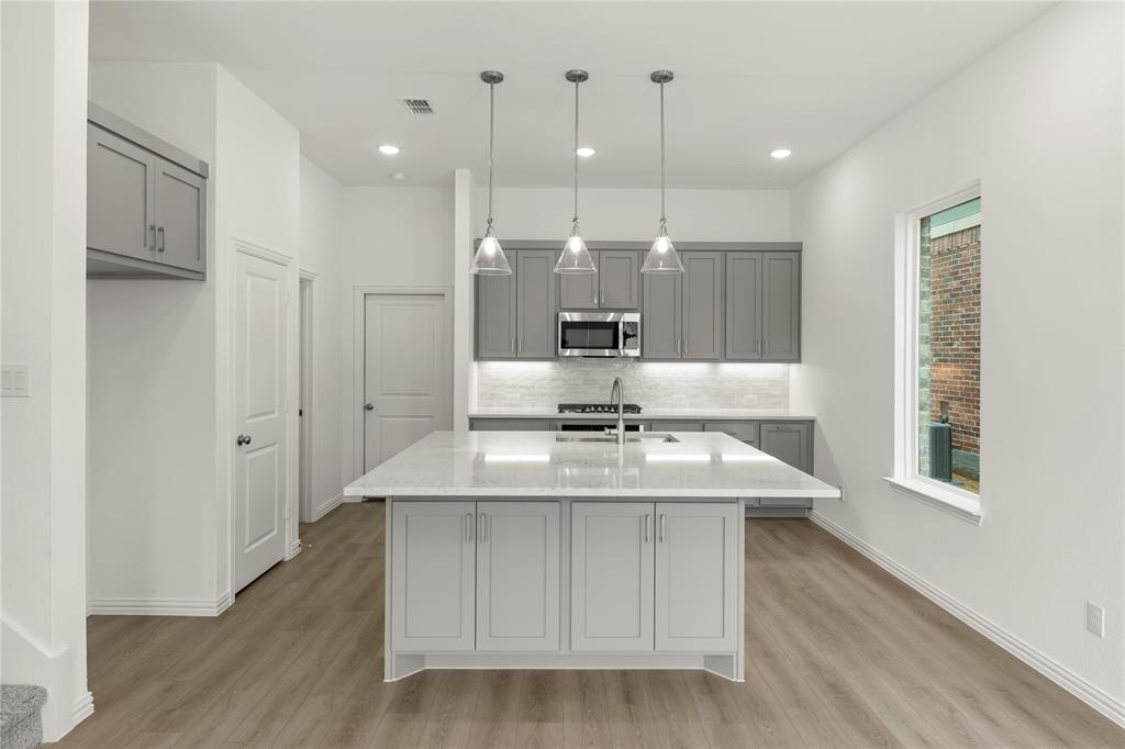 1114 Bexar Lane Plano, TX 75075 - Photo 1 of 1 a kitchen with kitchen island white cabinets stainless steel appliances and a counter space