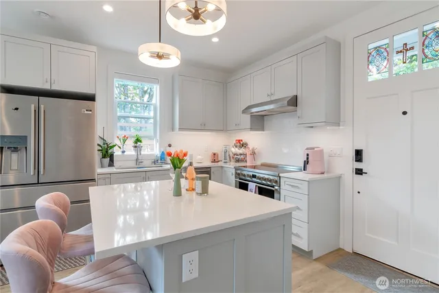 a kitchen with stainless steel appliances granite countertop a sink a stove and a refrigerator