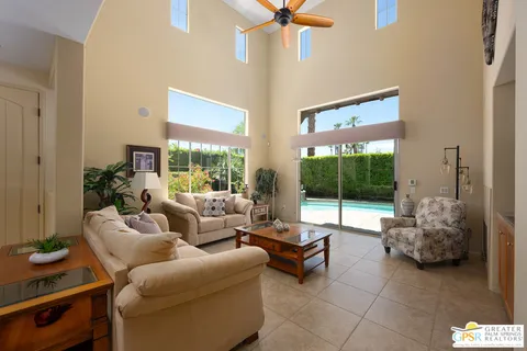 a living room with furniture and a floor to ceiling window