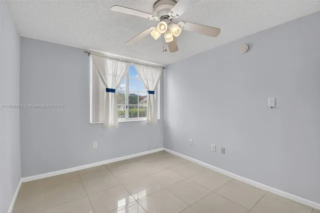 an empty room with closet and a ceiling fan