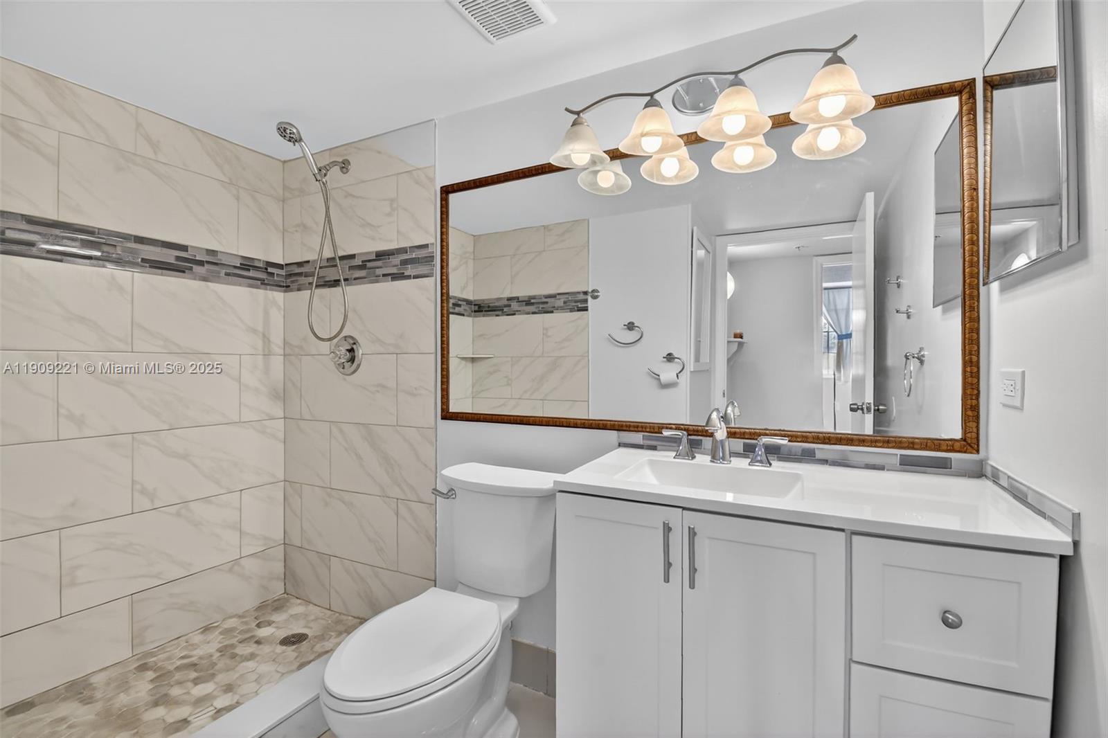 2123 Renaissance Boulevard, Unit 104 Miramar, FL 33025 - Photo 20 of 34 a bathroom with a sink vanity mirror and toilet