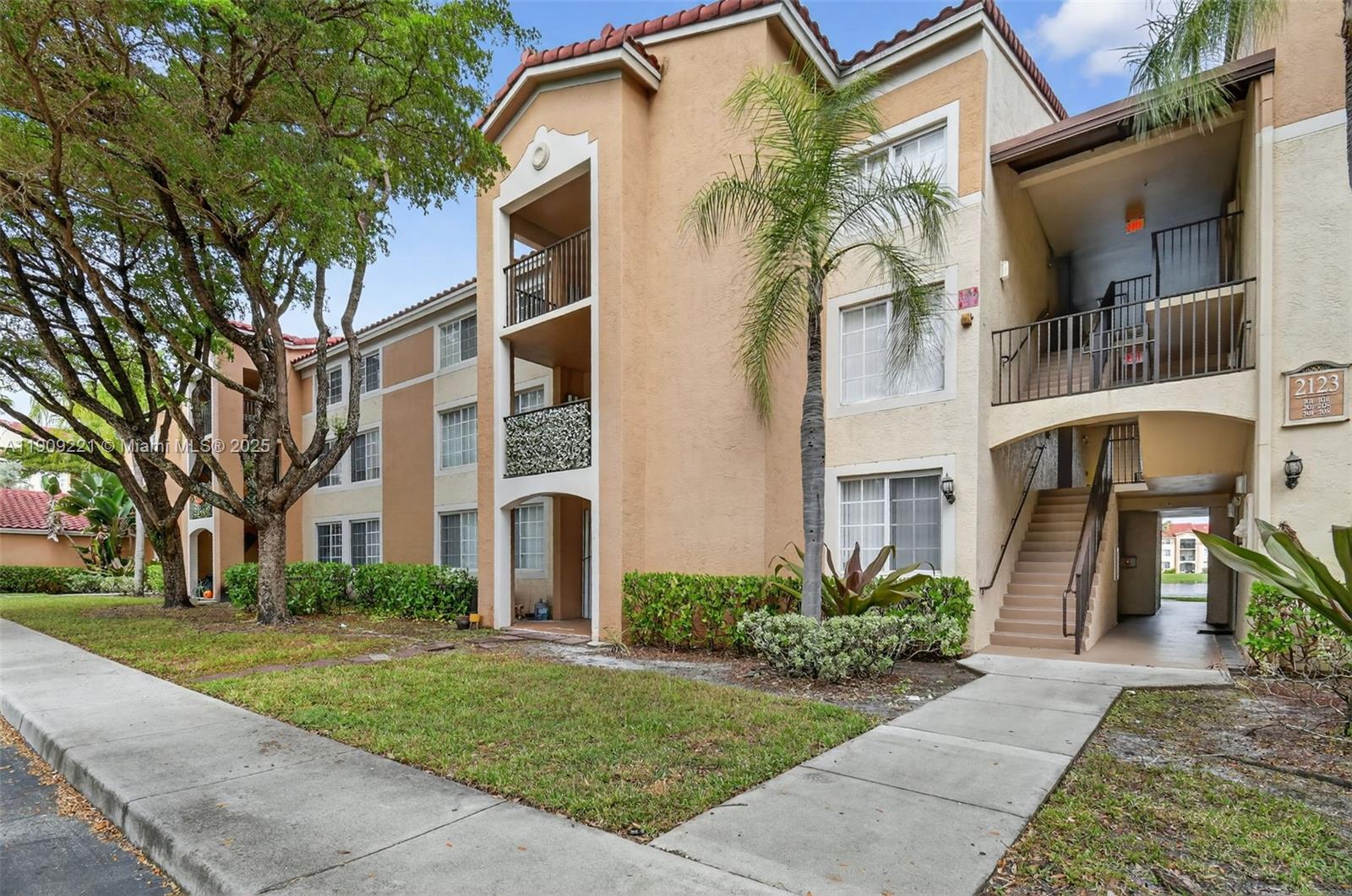 2123 Renaissance Boulevard, Unit 104 Miramar, FL 33025 - Photo 26 of 34 a front view of a building with a garden