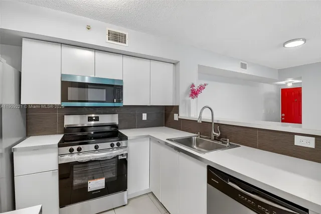 a kitchen with a sink stove top oven and cabinets