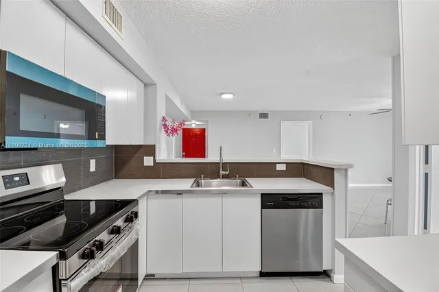 a kitchen with stainless steel appliances granite countertop a refrigerator and a microwave