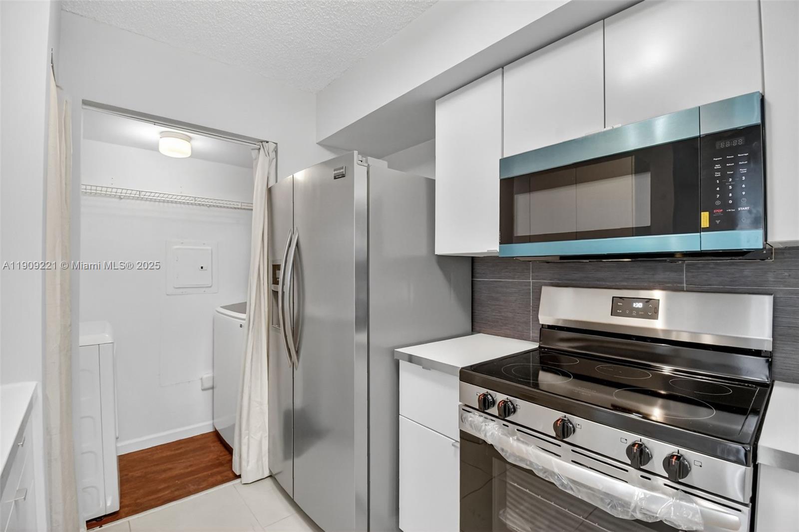 2123 Renaissance Boulevard, Unit 104 Miramar, FL 33025 - Photo 7 of 34 a kitchen with stainless steel appliances granite countertop a refrigerator and a microwave
