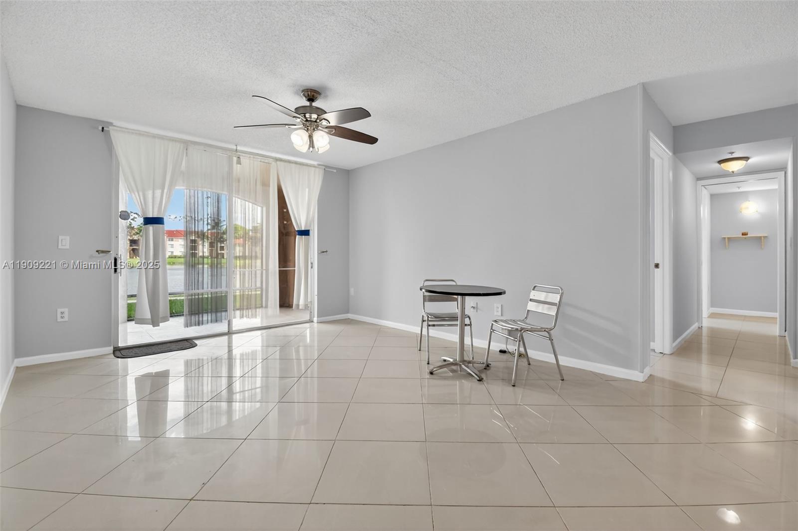 2123 Renaissance Boulevard, Unit 104 Miramar, FL 33025 - Photo 8 of 34 a room with furniture and a chandelier