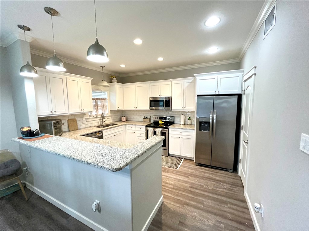 344 Bay View Boulevard, Unit A Portland, TX 78374 - Photo 4 of 8 a kitchen with stainless steel appliances granite countertop a sink a stove a refrigerator and a center island