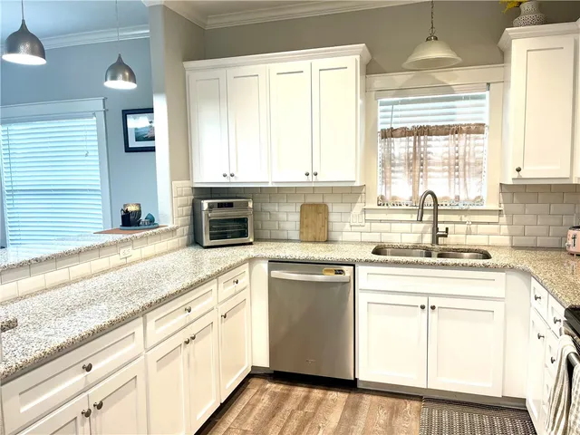 a kitchen with granite countertop white cabinets and white appliances