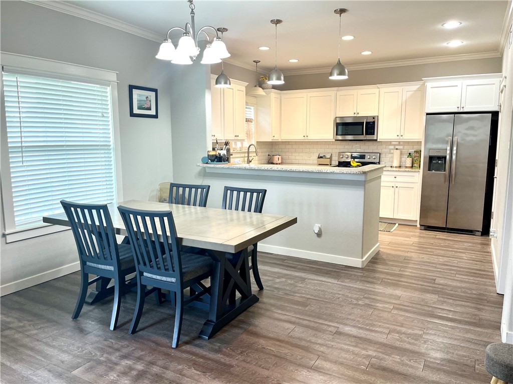 344 Bay View Boulevard, Unit A Portland, TX 78374 - Photo 7 of 8 a kitchen with stainless steel appliances granite countertop a kitchen island hardwood floor and a sink