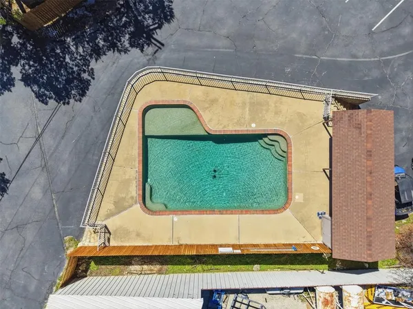 an aerial view of a house with swimming pool and furniture