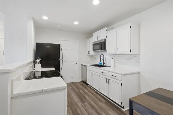 a kitchen with a sink stove and microwave