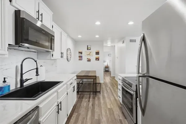 a kitchen with stainless steel appliances a stove a sink and a microwave