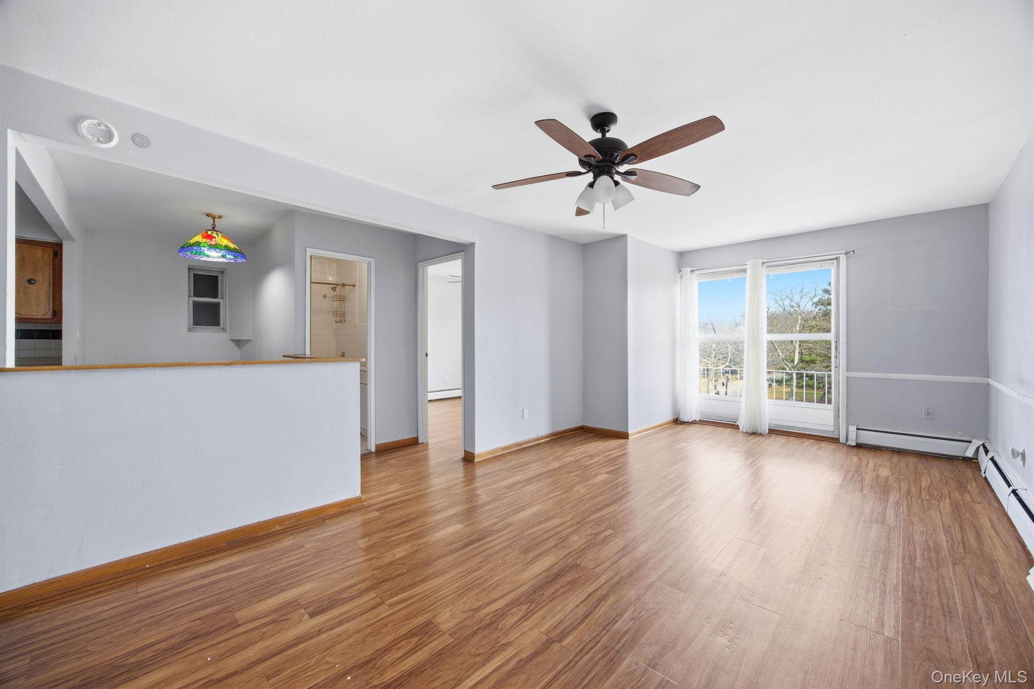 49-12 111th Street Queens, NY 11368 - Photo 16 of 31 a view of a livingroom with a hardwood floor and a ceiling fan