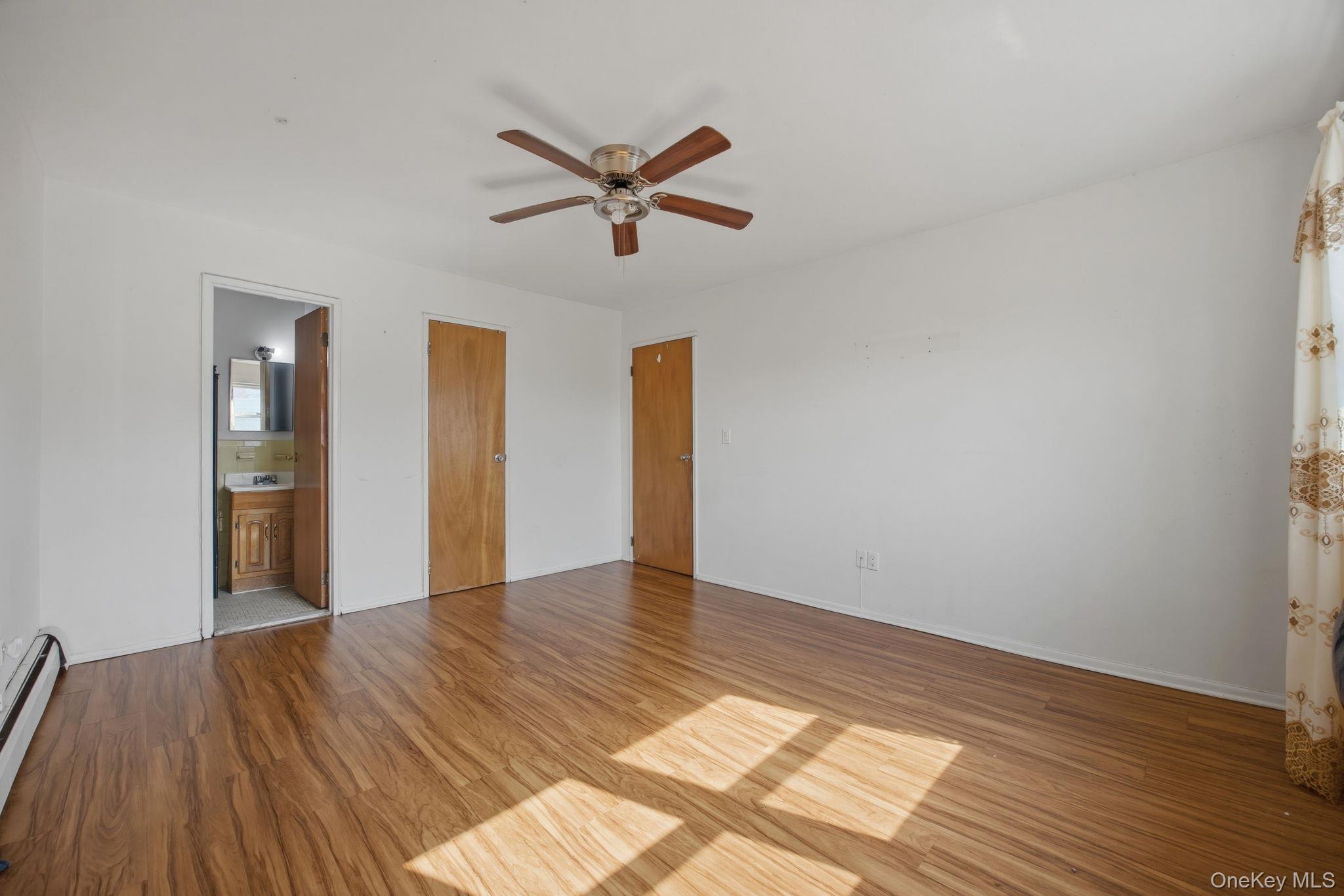 49-12 111th Street Queens, NY 11368 - Photo 24 of 31 a view of empty room with wooden floor and fan
