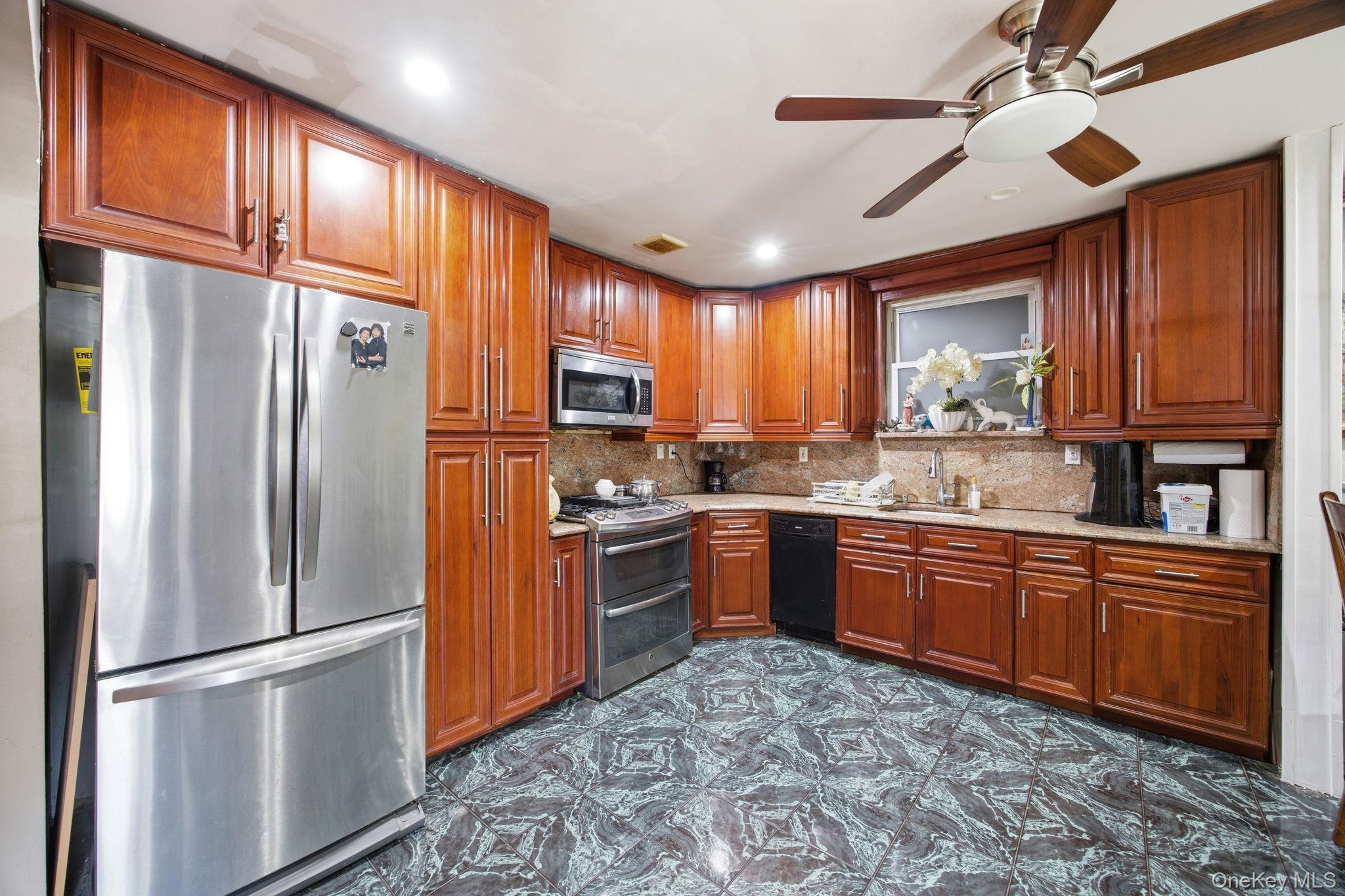 49-12 111th Street Queens, NY 11368 - Photo 7 of 31 a kitchen with stainless steel appliances granite countertop a refrigerator a stove a sink and dishwasher