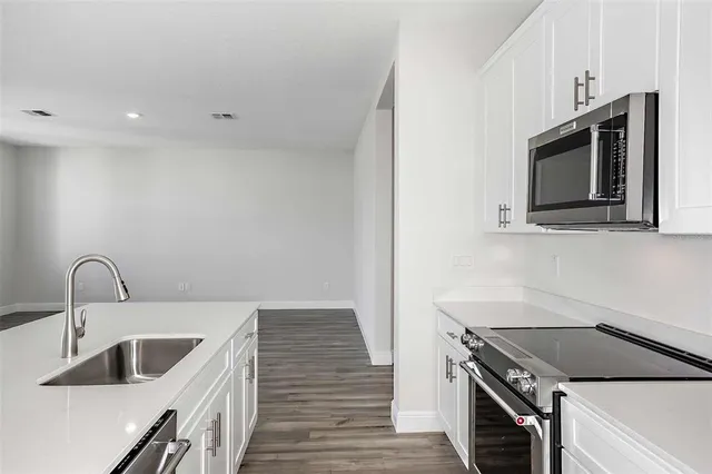 a kitchen with stainless steel appliances granite countertop a sink and a stove top oven
