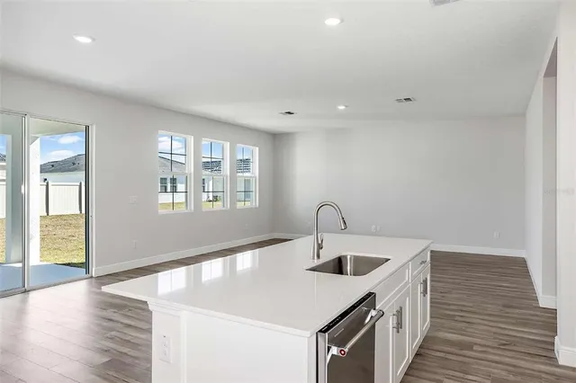 a kitchen with a sink cabinets and wooden floor
