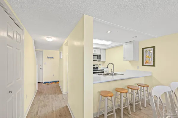 a kitchen with stainless steel appliances a refrigerator a sink a stove and white cabinets