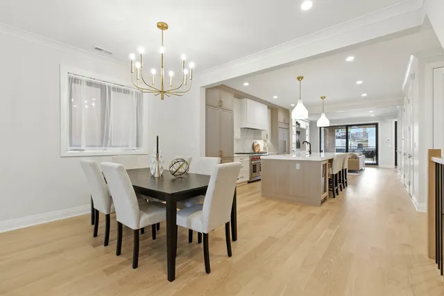 a dining room with kitchen island a chandelier dining table and chairs