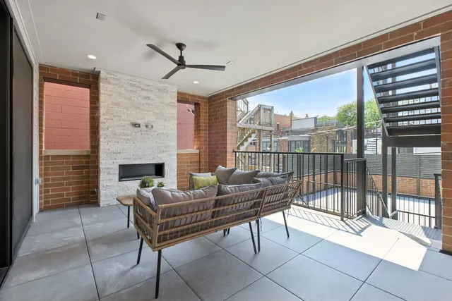 a living room with furniture a fireplace and a floor to ceiling window