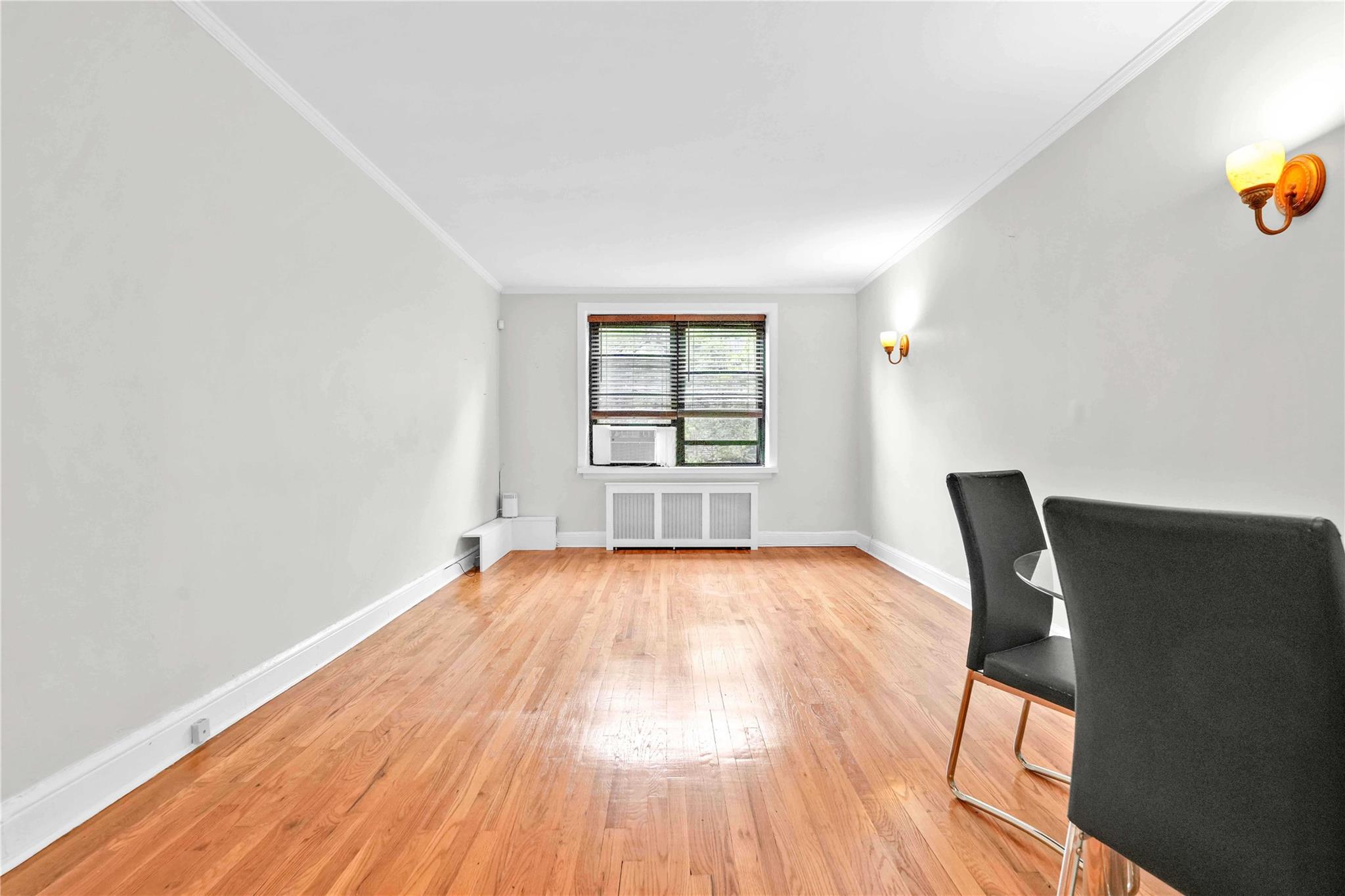 21-40 78th Street, Unit 2 Queens, NY 11370 - Photo 2 of 11 an empty room with wooden floor and windows