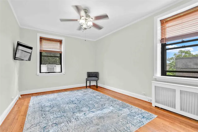 a view of an empty room with window and wooden floor