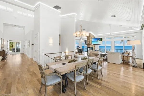 a dining room with wooden floor a chandelier a wooden table and chairs