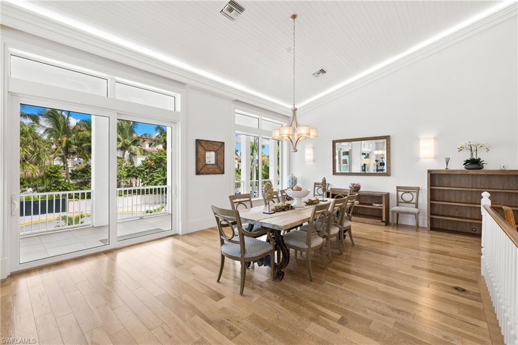 40 32nd Avenue South Naples, FL 34102 - Photo 16 of 49 Dining room featuring light wood-type flooring, a chandelier, high vaulted ceiling, and ornamental molding
