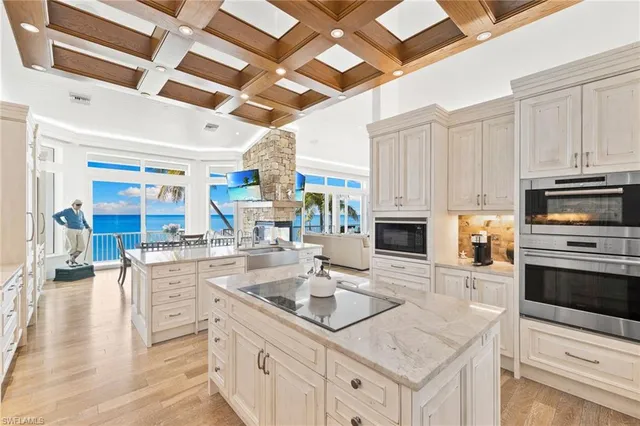 a large white kitchen with cabinets and wooden floor