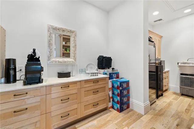 a kitchen with stainless steel appliances granite countertop a table chairs and a refrigerator