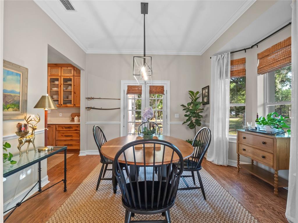 6037 Lake Erie Road Groveland, FL 34736 - Photo 18 of 67 a dining room with furniture a chandelier and wooden floor