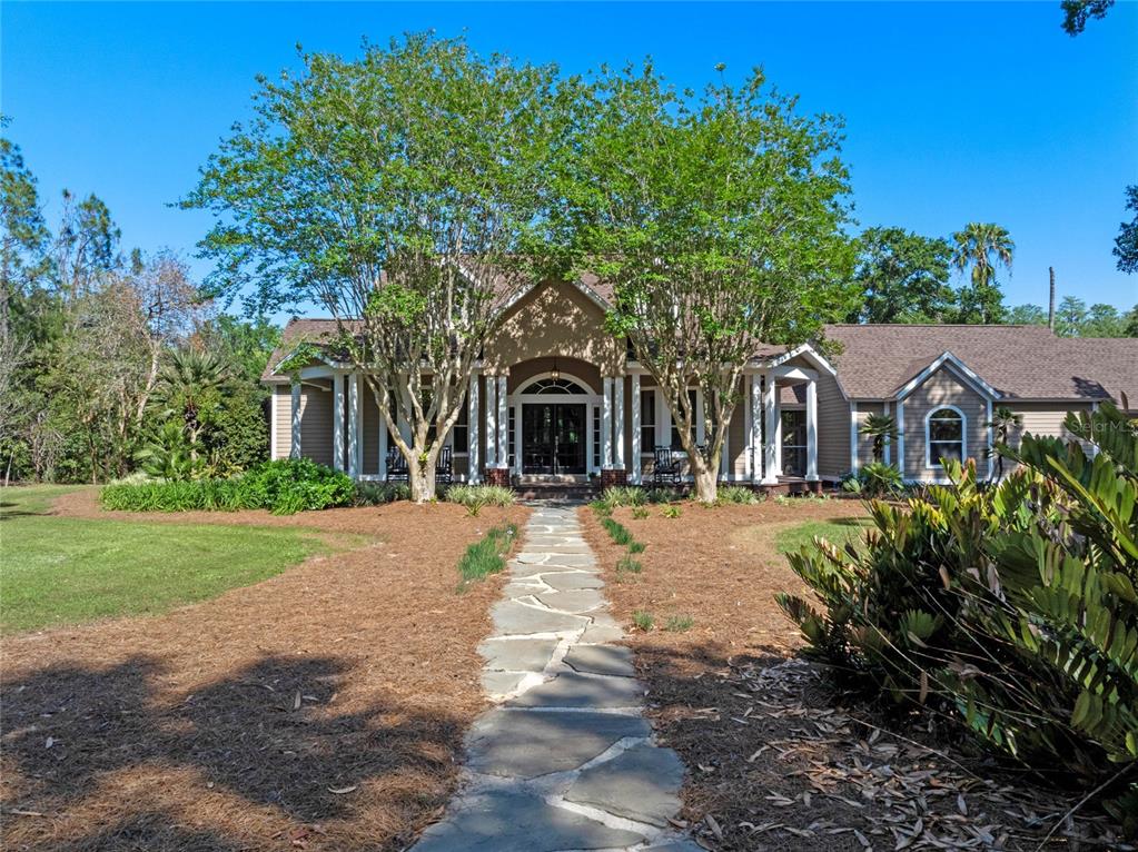 6037 Lake Erie Road Groveland, FL 34736 - Photo 2 of 67 a front view of a house with garden and trees