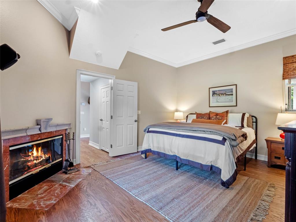 6037 Lake Erie Road Groveland, FL 34736 - Photo 31 of 67 a spacious bedroom with a bed and a fireplace