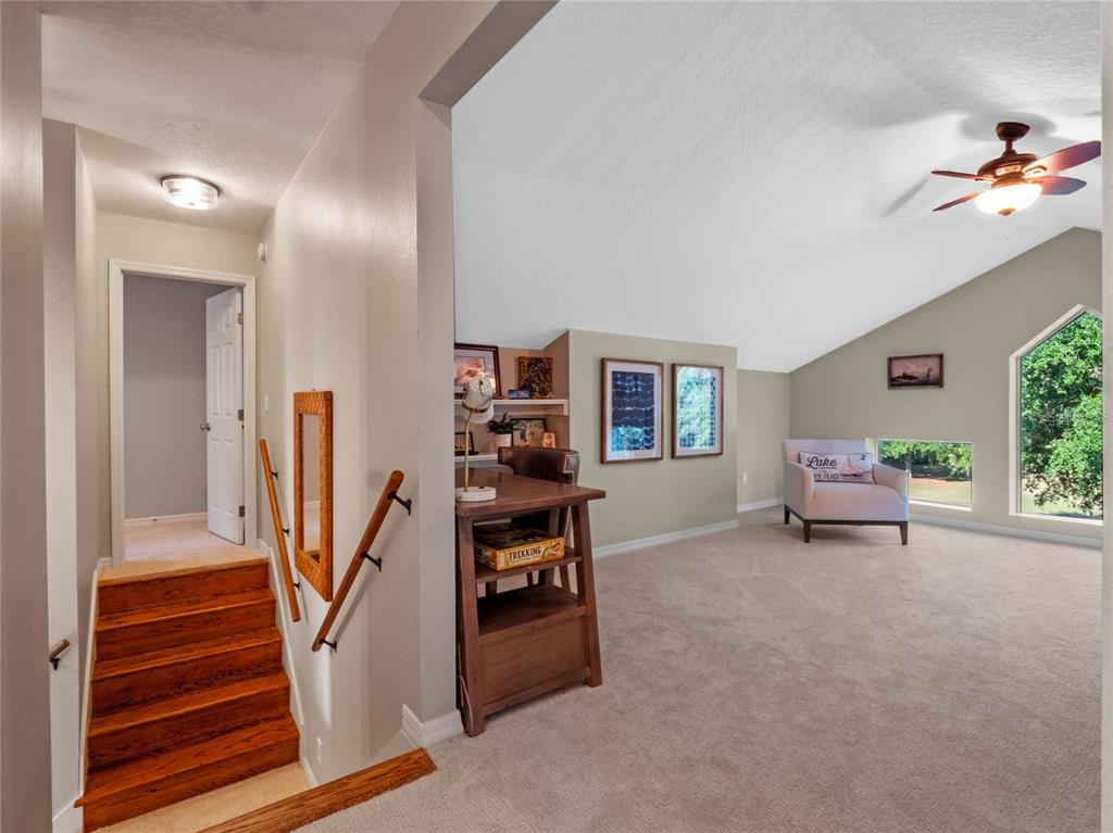 6037 Lake Erie Road Groveland, FL 34736 - Photo 36 of 67 a living room with furniture and a chandelier