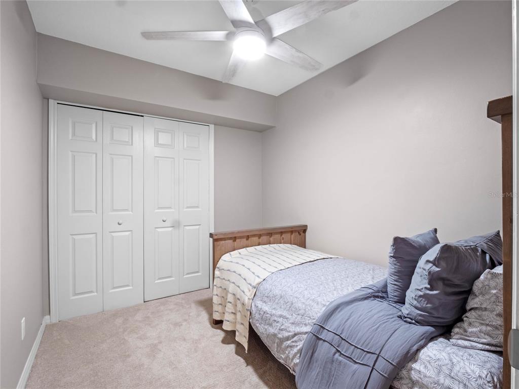 6037 Lake Erie Road Groveland, FL 34736 - Photo 41 of 67 a bedroom with a bed and a ceiling fan