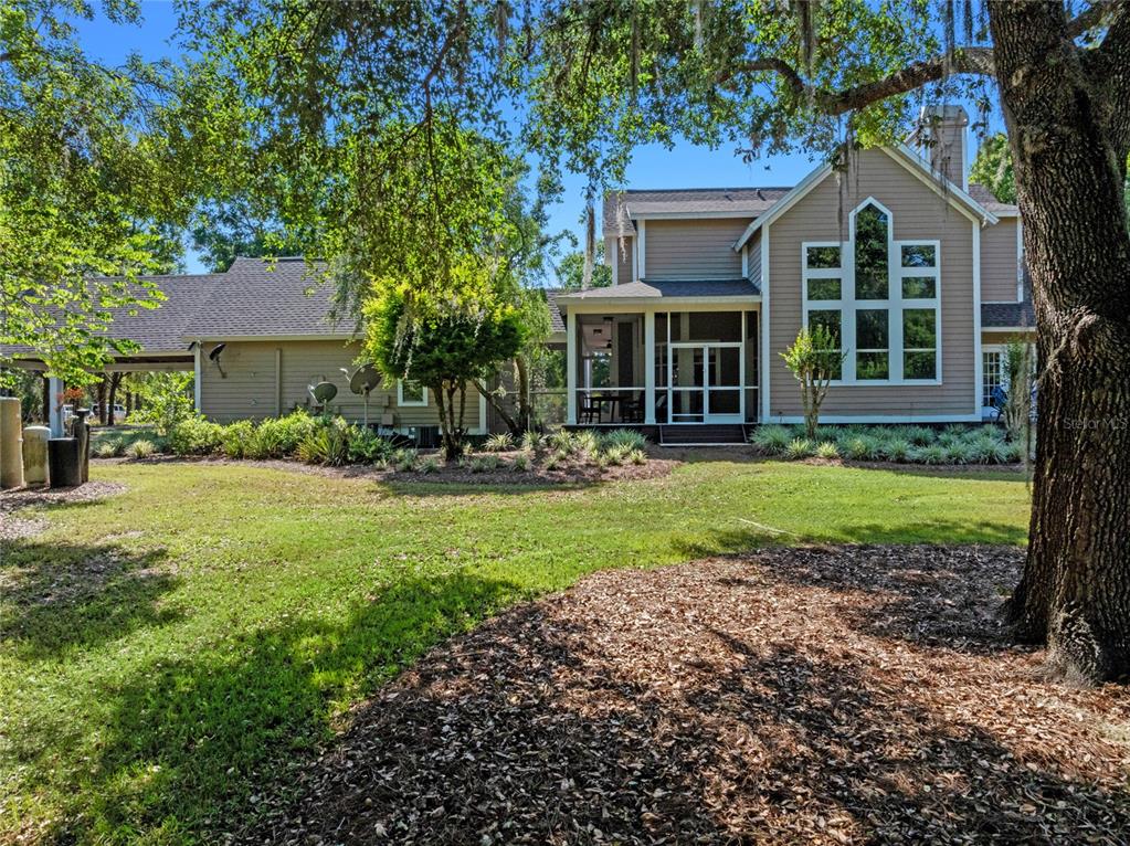 6037 Lake Erie Road Groveland, FL 34736 - Photo 6 of 67 a front view of a house with a yard and trees