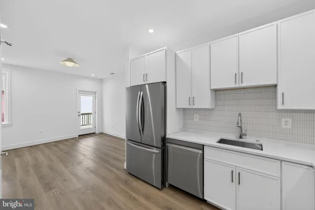 a kitchen with stainless steel appliances a refrigerator sink and cabinets