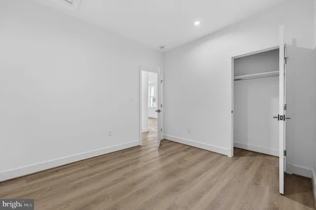 an empty room with wooden floor and closet