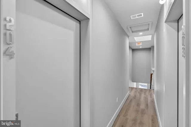a view of a hallway with wooden floor