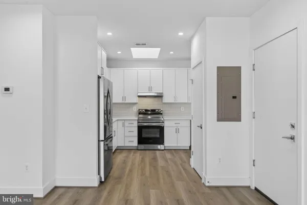 a kitchen with stainless steel appliances granite countertop a refrigerator and a stove top oven