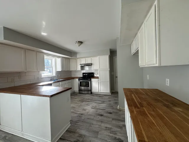 a kitchen with kitchen island granite countertop a sink and stove
