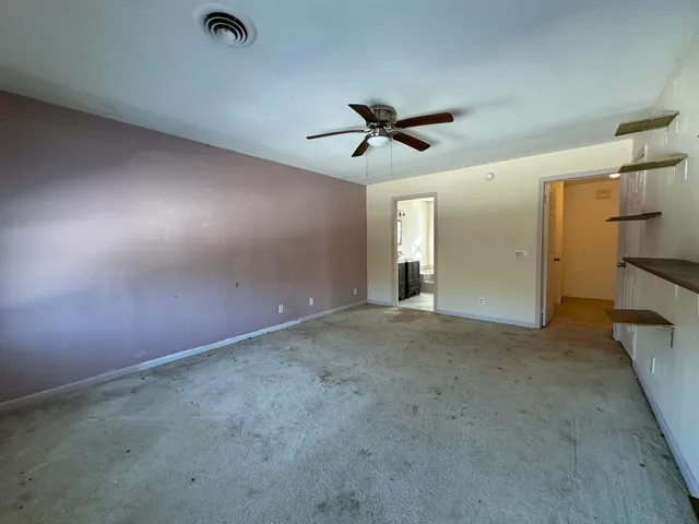 en empty room with windows and ceiling fan