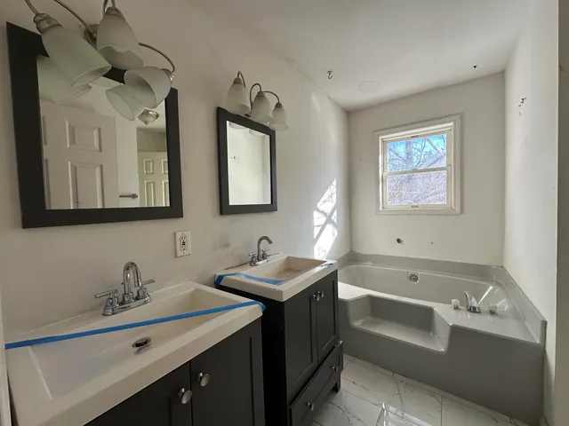 a white toilet sitting next to a small window