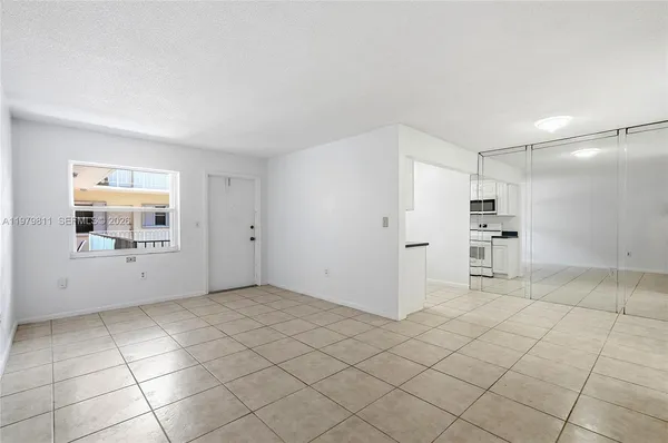 a kitchen with granite countertop a refrigerator and a stove top oven